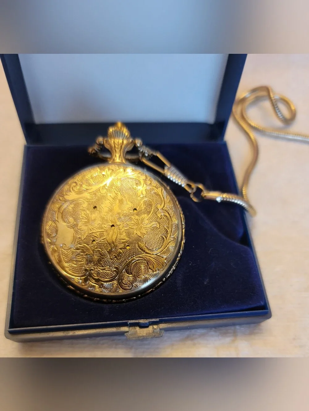 Vintage gold-tone pocket watch has a raised steam engine train motif.